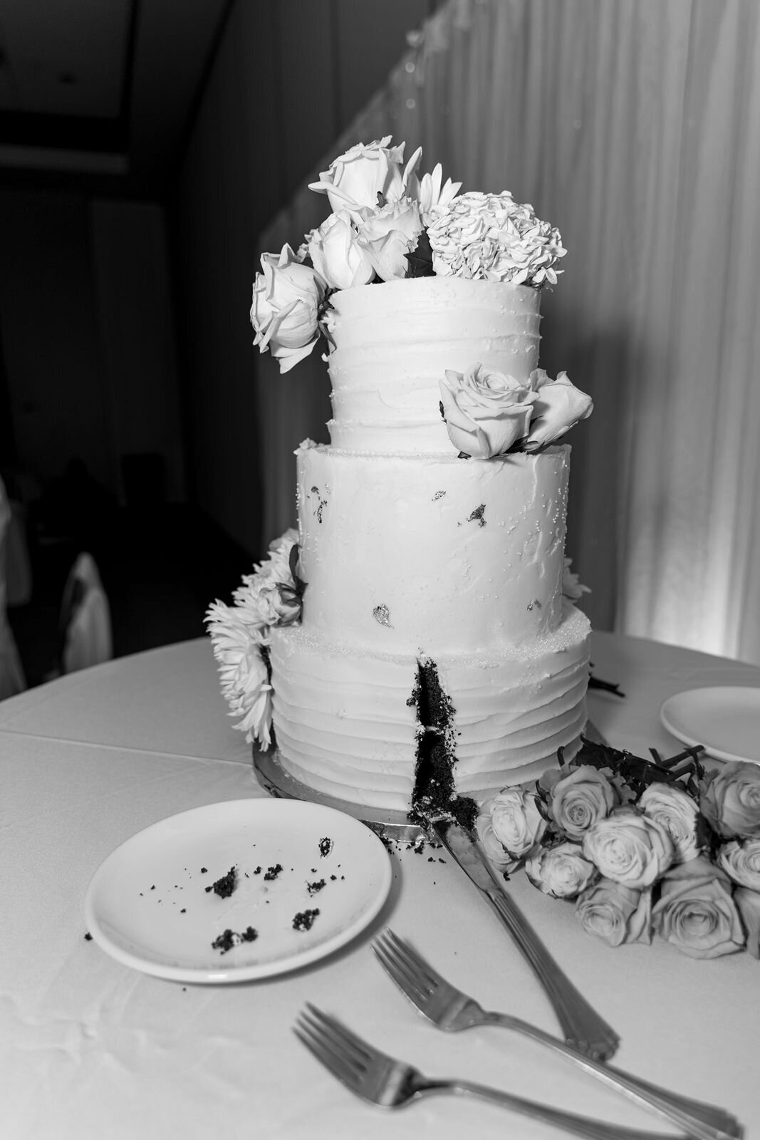 a black and white photo of the a wedding cake after being cut