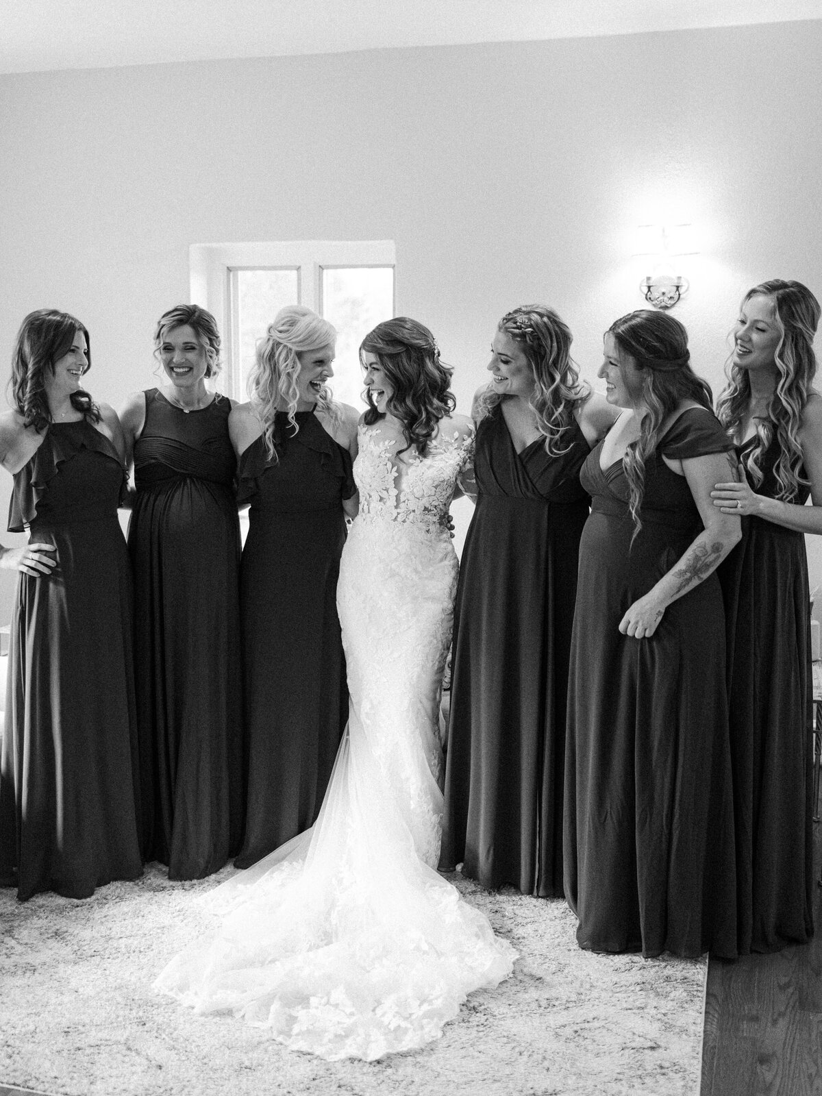 A bride standing arm in arm with her six bridesmaids
