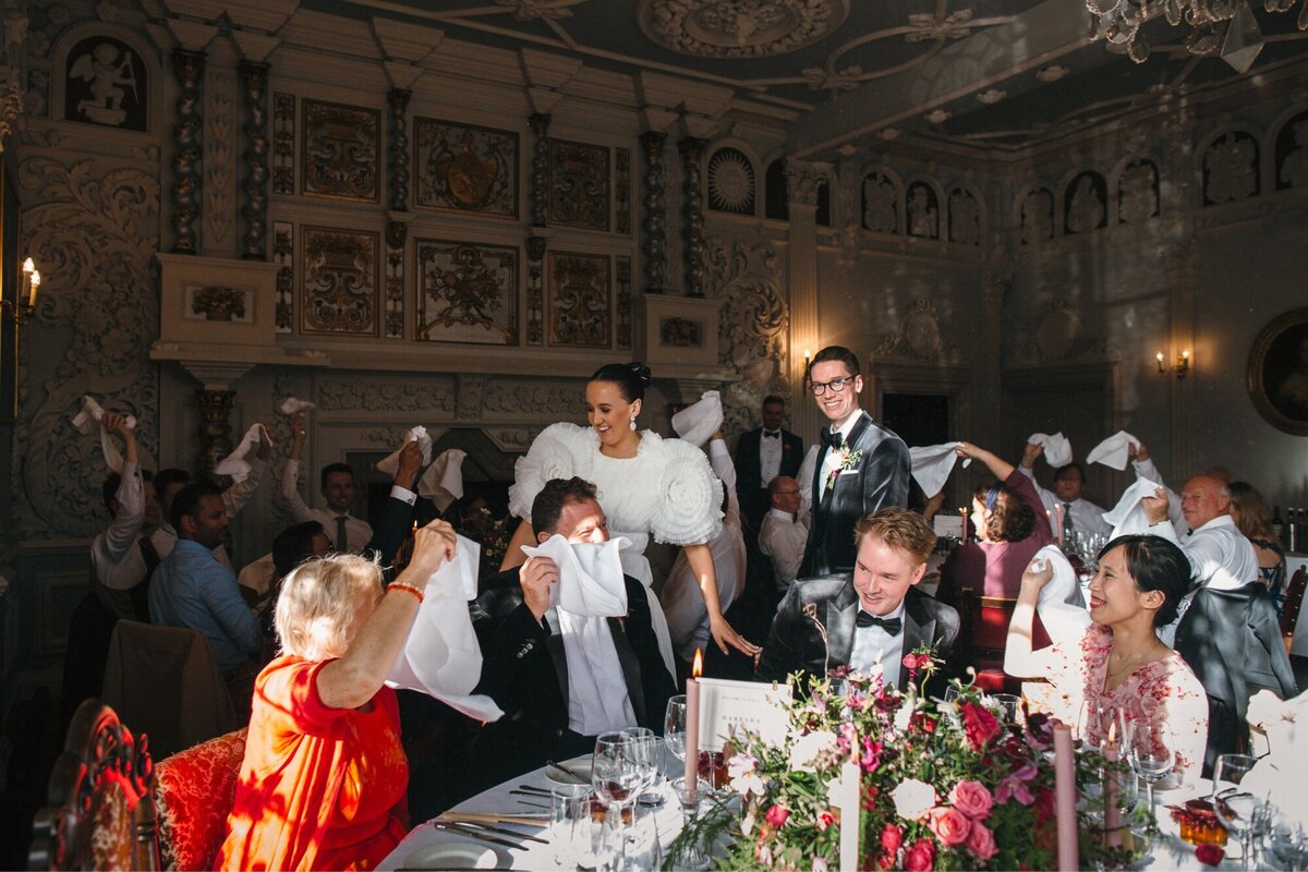 Couple enter wedding breakfast with swinging napkins and cheering