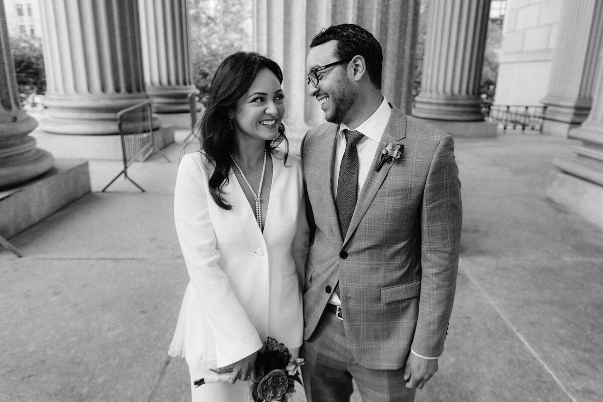 The bride and groom are happily looking at each other's eyes at the NY City Hall. Image by Jenny Fu Studio