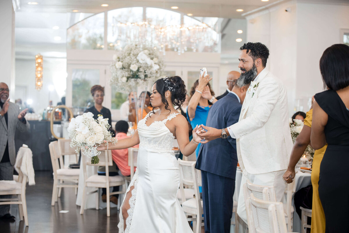 A joyful moment as the newlyweds raise their hands, celebrating their big day.
