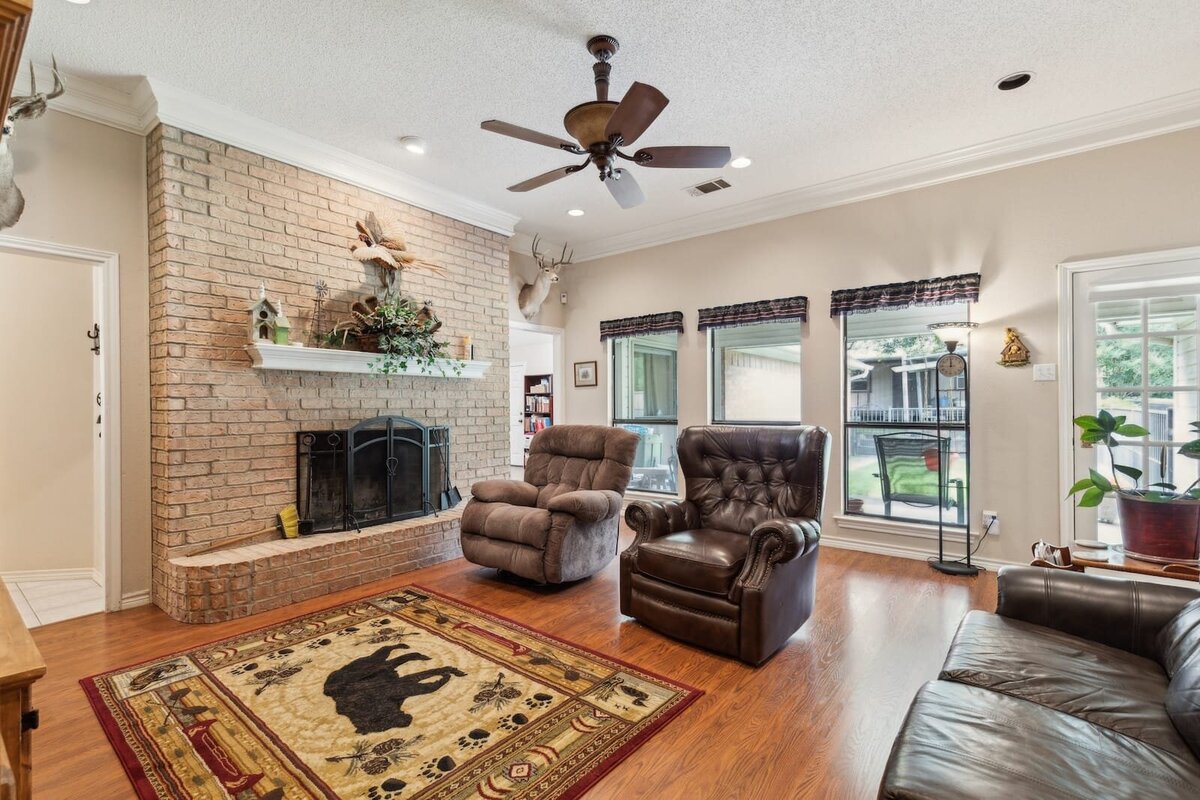6419_shadow_lane_dallas_tx_living_room_fireplace_view_-_brick_fireplace_and_large_windows_-_haven_realty_group