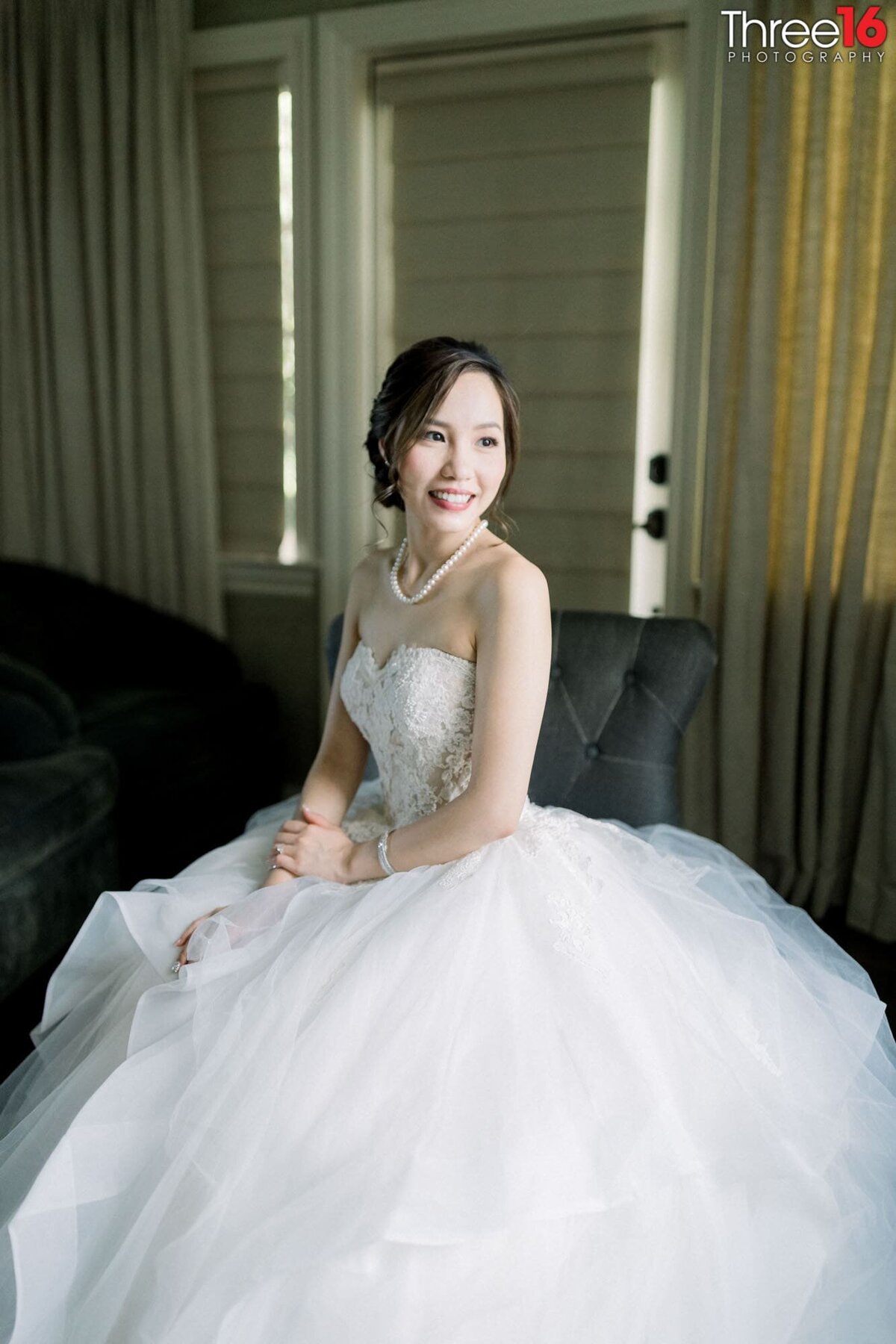 Bride smiles as she sits with her wedding gown fluffed out