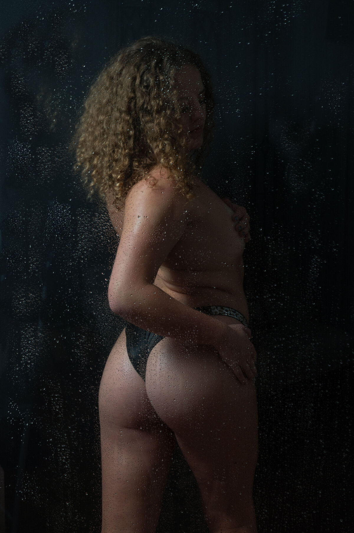 A woman in a shower being photographed by Orlando boudoir photographer Khim Higgins.