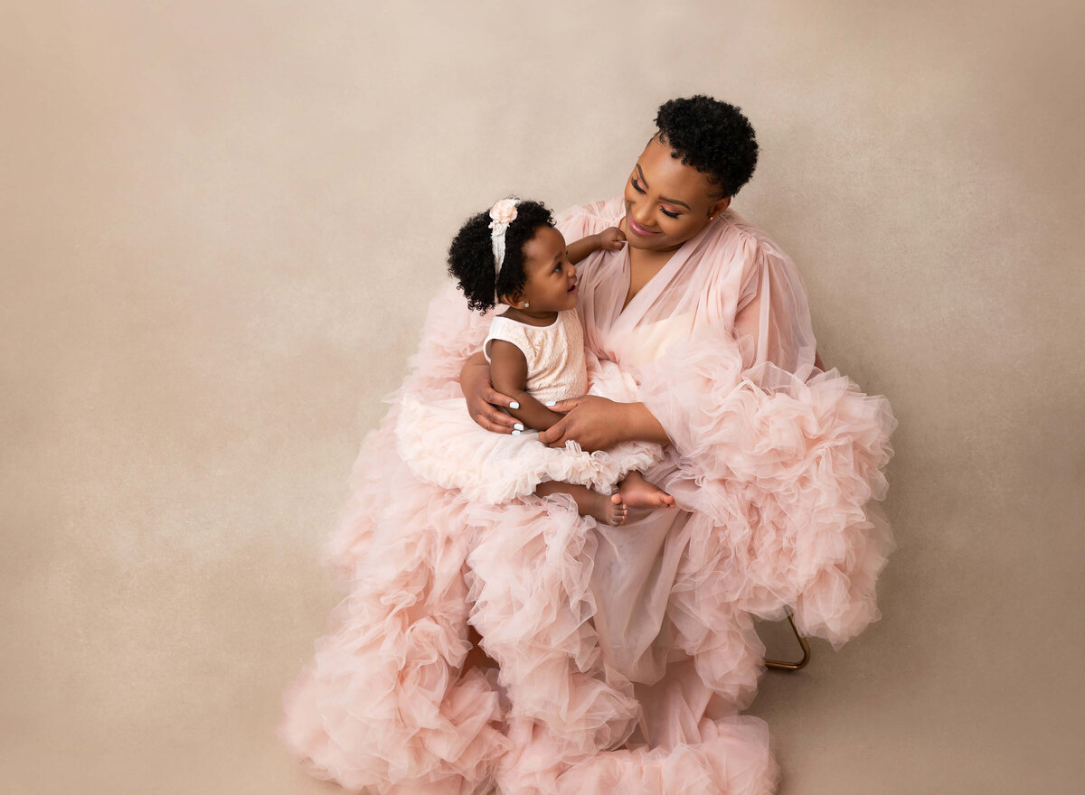 Mom holding her baby girl  for baby pictures in New york photo studio