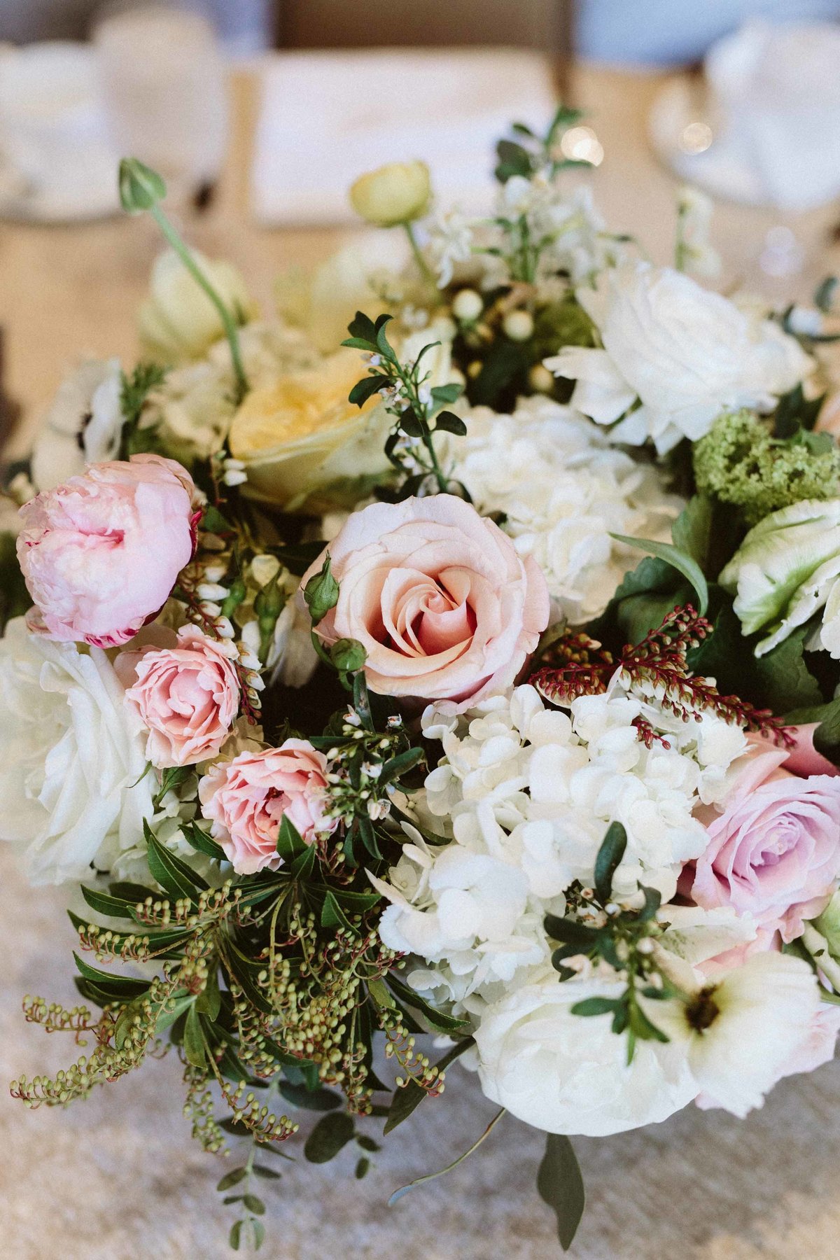 centerpiece detail with pink roses, spray roses, white hydrangea, spirea,, and anemones