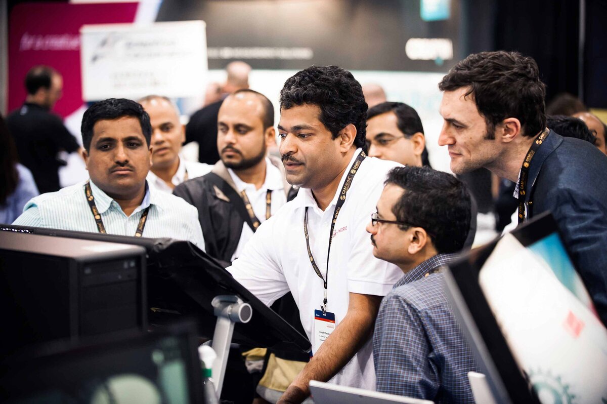 A crowd looks at a design on a computer screen at Solidworks world