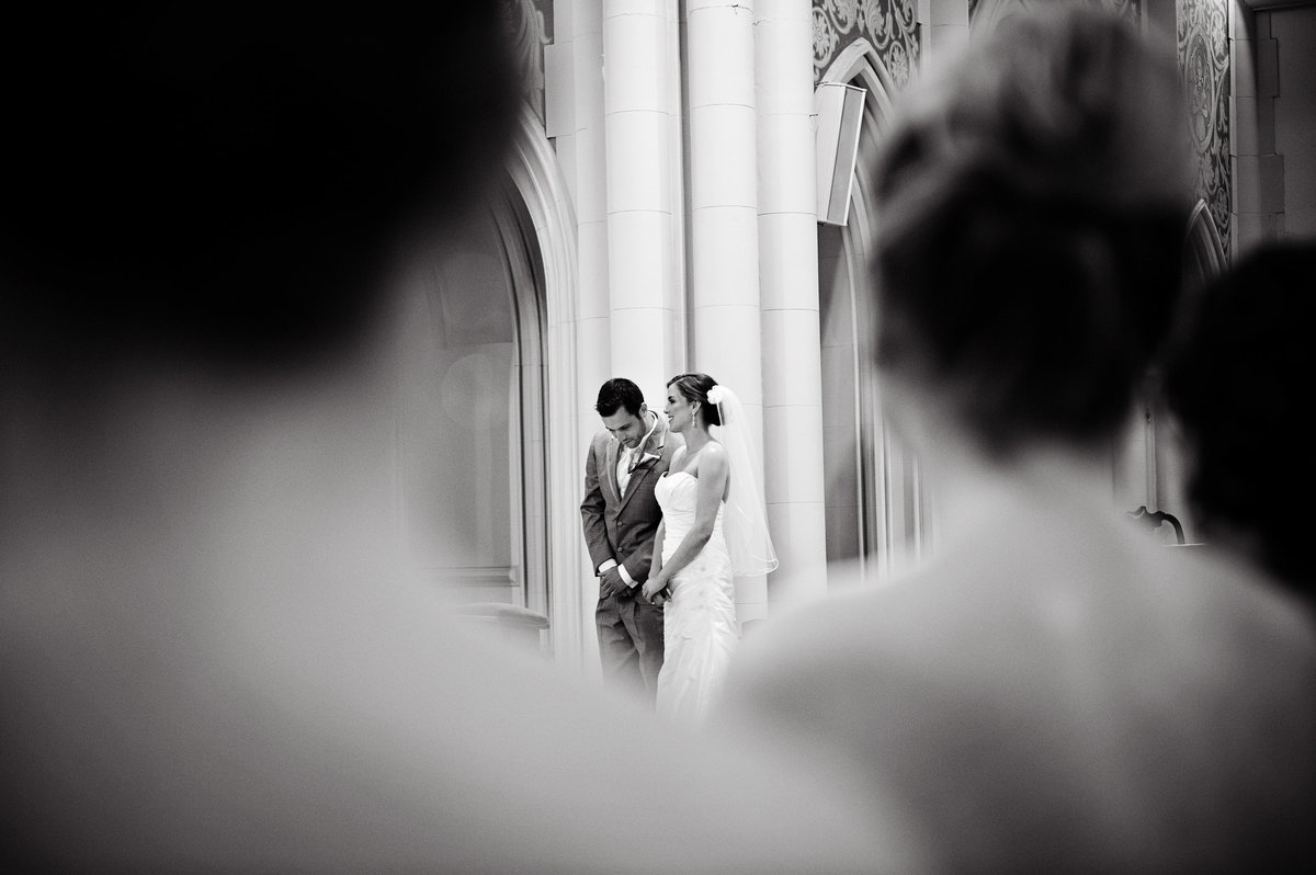 A groom looks over at his bride during their Catholic ceremony in Philadelphia.