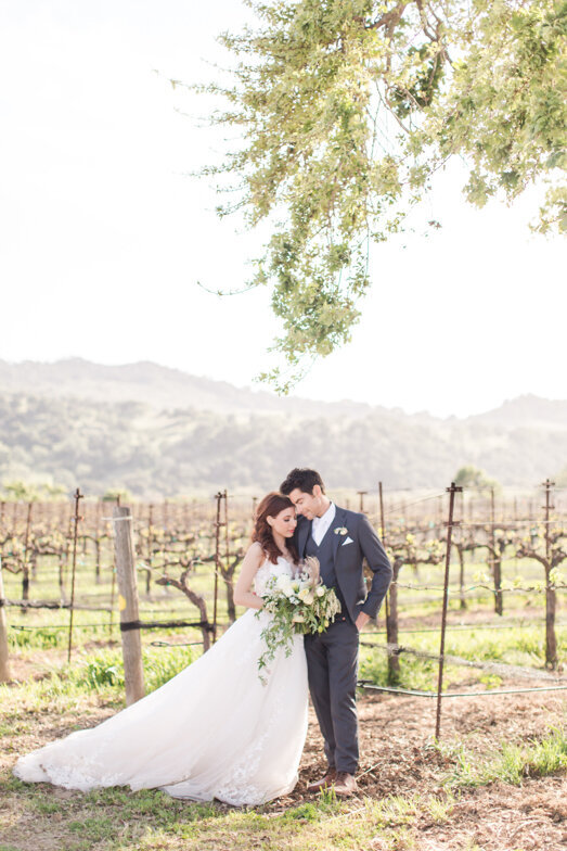bride and groom in vineyard at Sunstone Winery