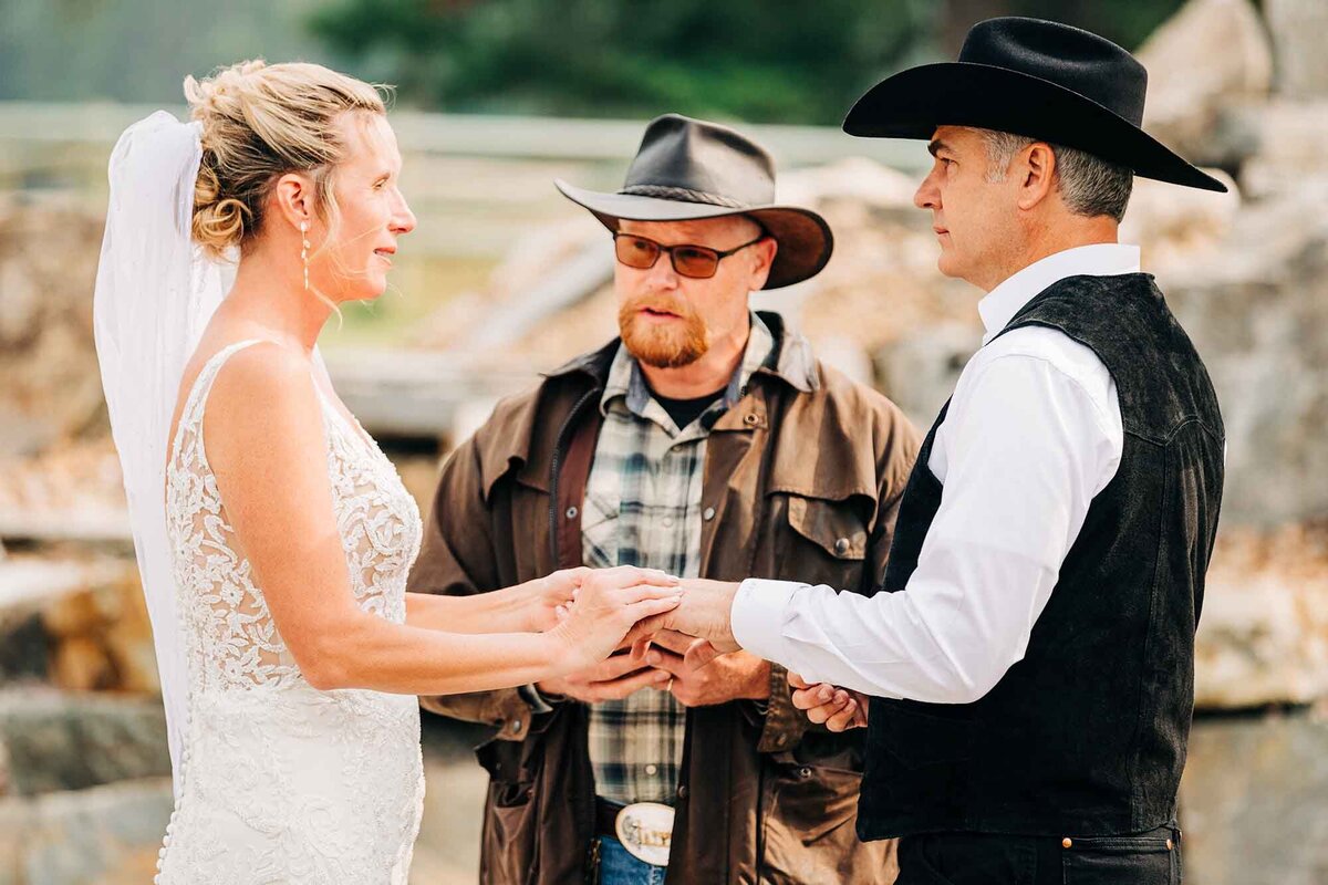 Bride and groom exchanging rings, The Silver Knot, Ronan, MT