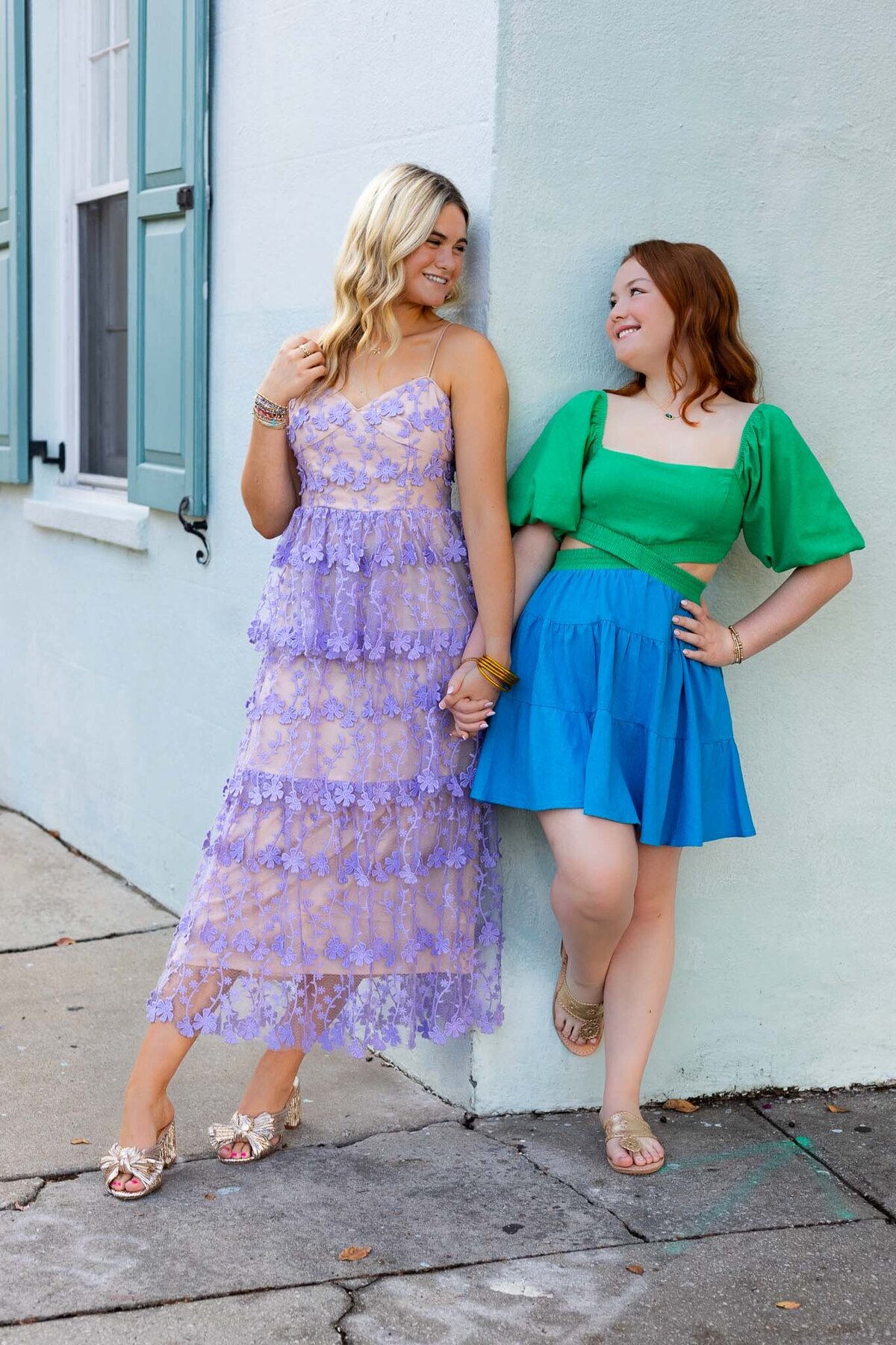 MBP Senior Team holding hands leaning against a wall looking at each other in Lawrence, KS