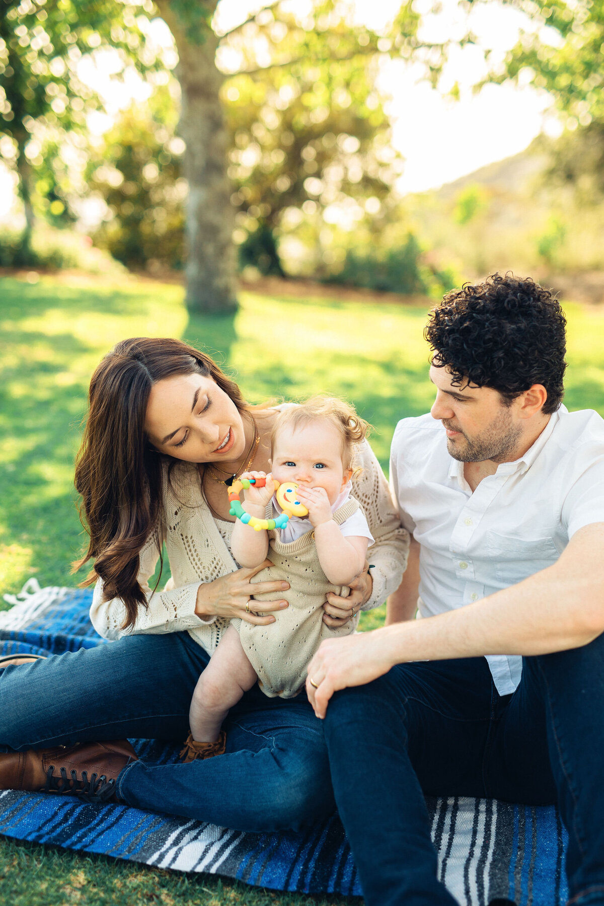 Family Portrait Photo Of Couple Looking At Their baby Biting a Teether Los Angeles