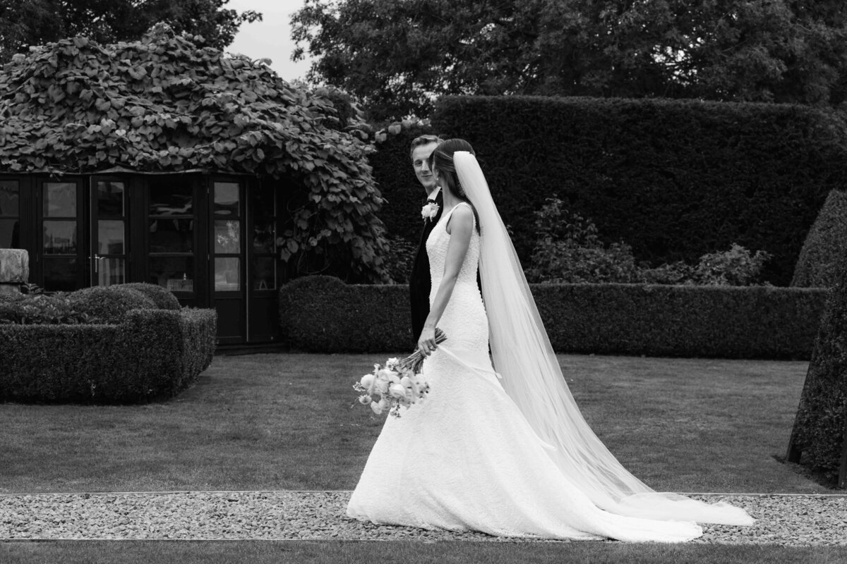 A bride and groom walk through the grounds at a luxury wedding venue
