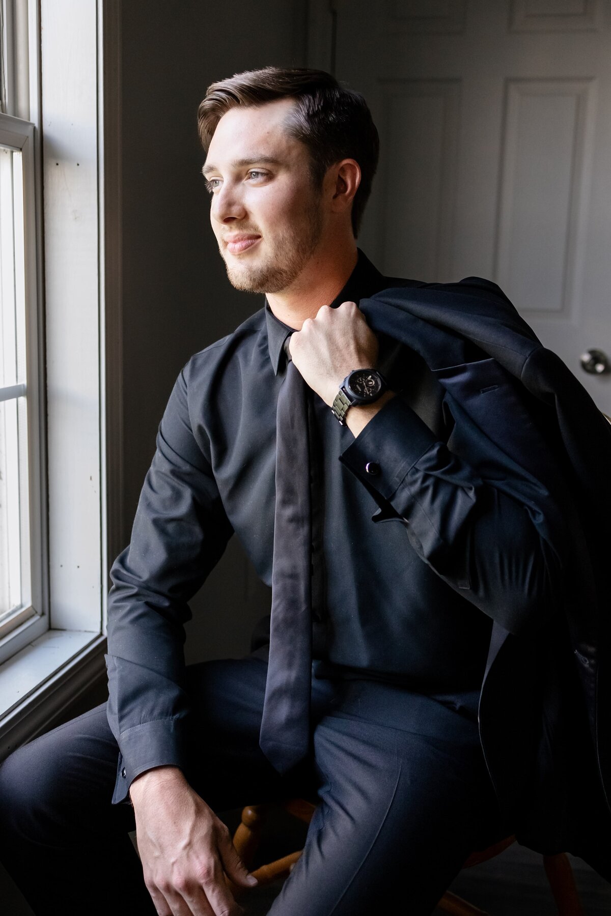 Groom looks out of window for local tennessee ceremony