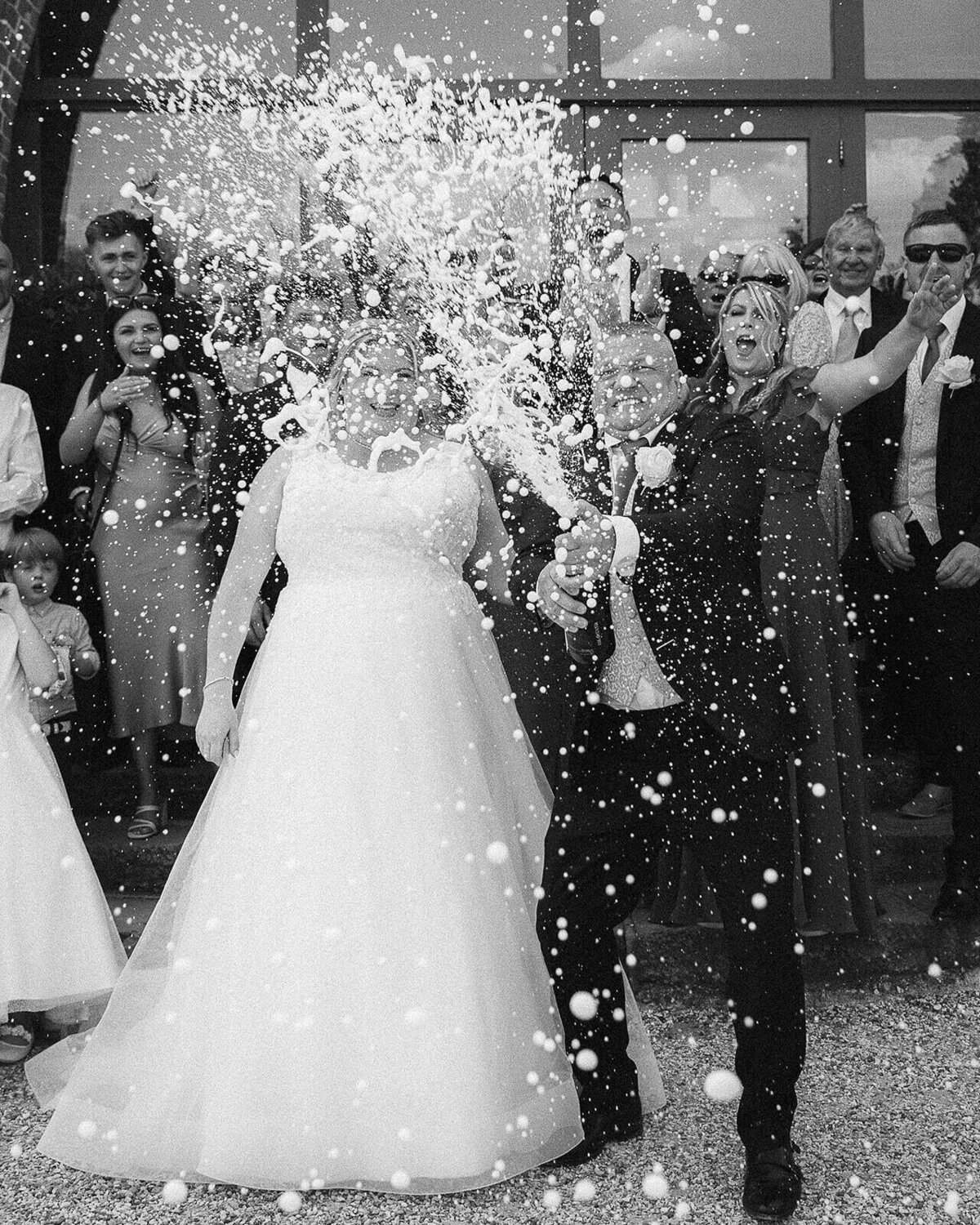 Bride and groom spray champagne. 
