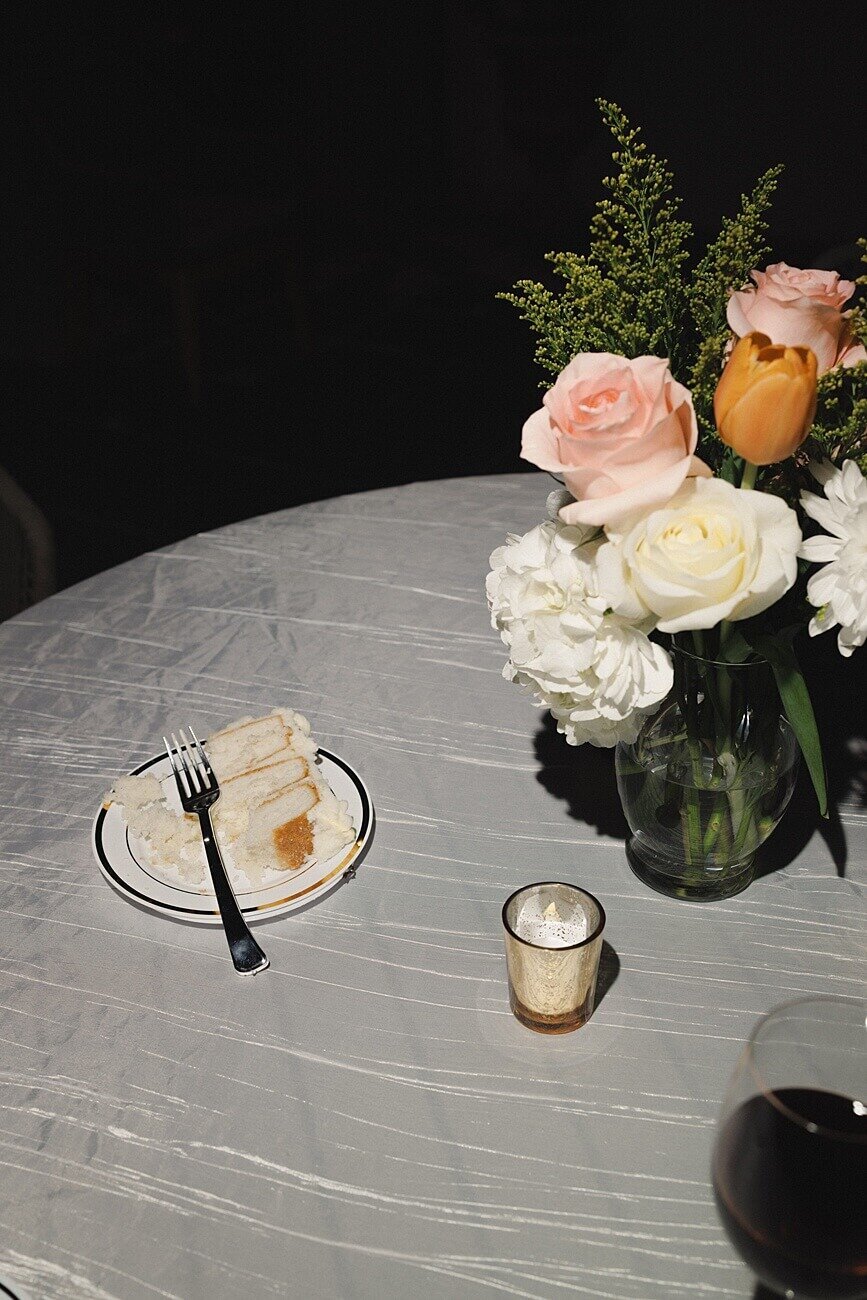cake and floral arrangement on wedding reception table