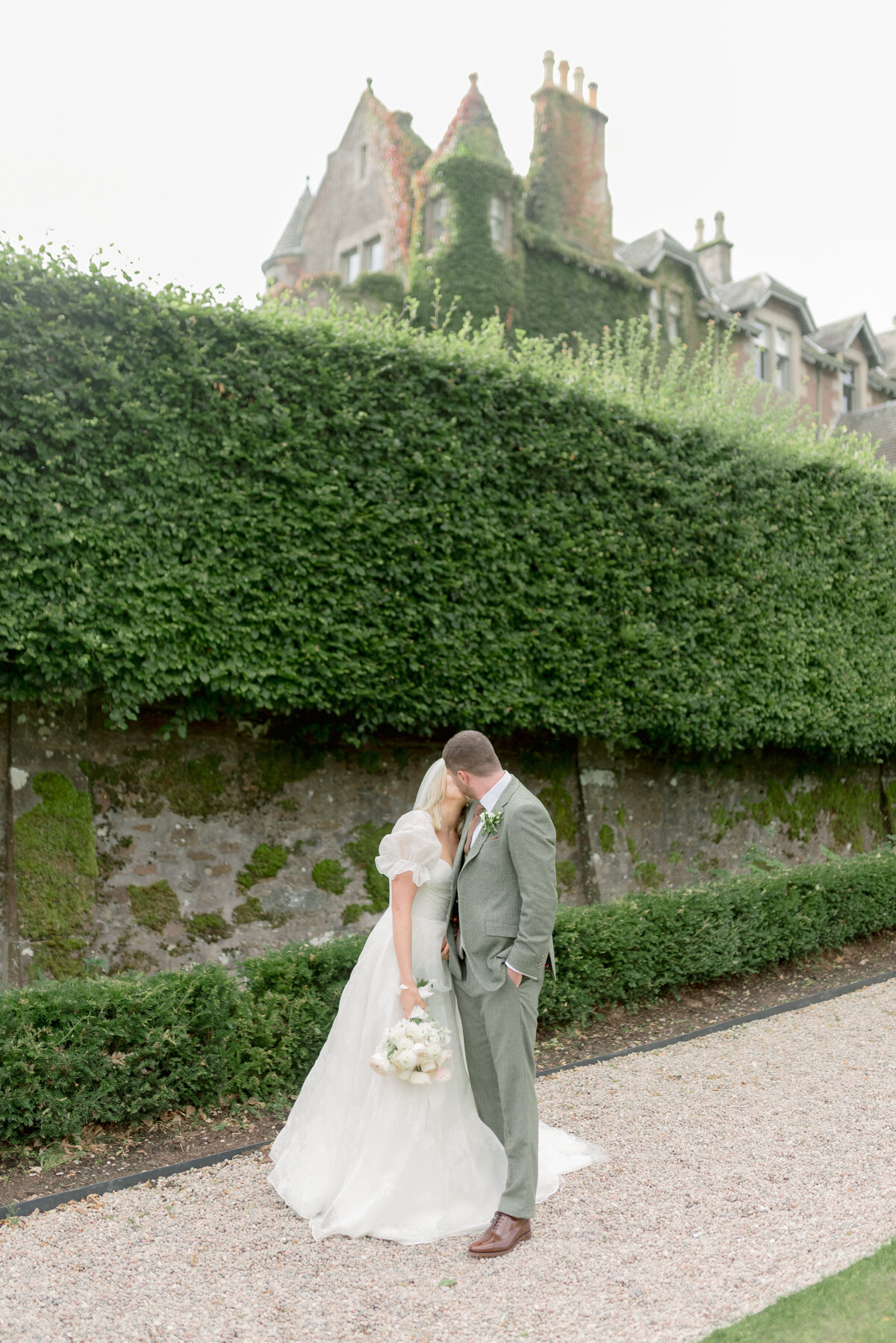 Bride and Groom with the backdrop of Cromlix House, Scotland, on their summer wedding day, photographed by fine art wedding photographer UK.
