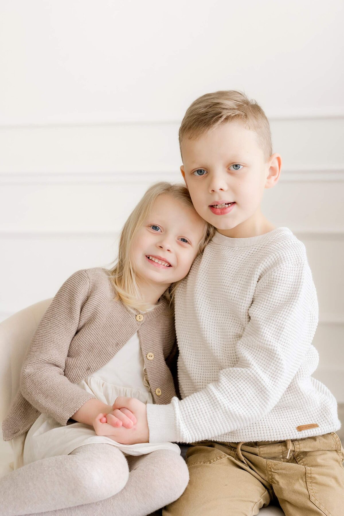 Alexandra Robyn Photo + Design captures playful family portraits in a minimalist, all-white studio setting with a joyful family