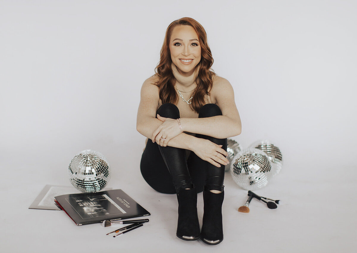 Makeup artist sitting on floor with makeup products