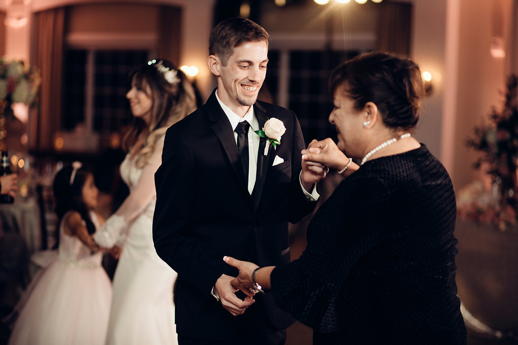 Wedding Photograph Of Groom In Black Suit Holding Hands With Woman In Black Suit Los Angeles