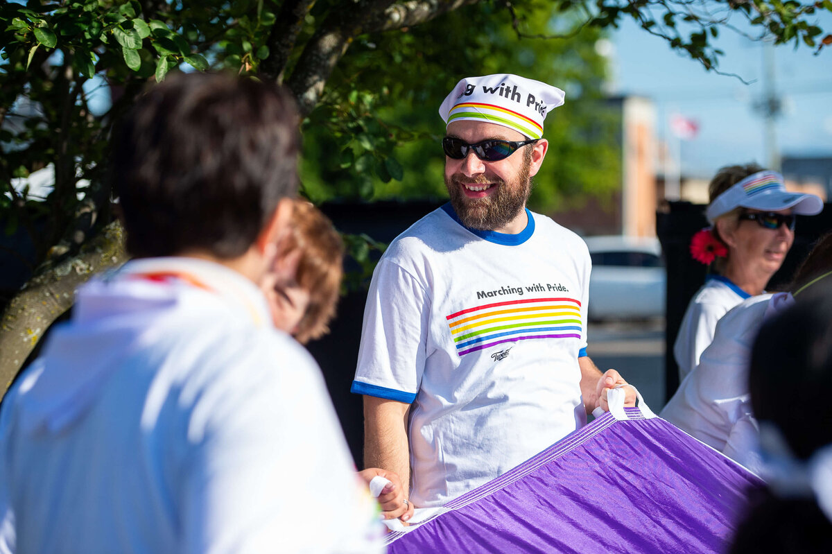 Ottawa event photography showing pride marches waving a purple pride parachute. Captured by JEMMAN Photography COMMERCIAL