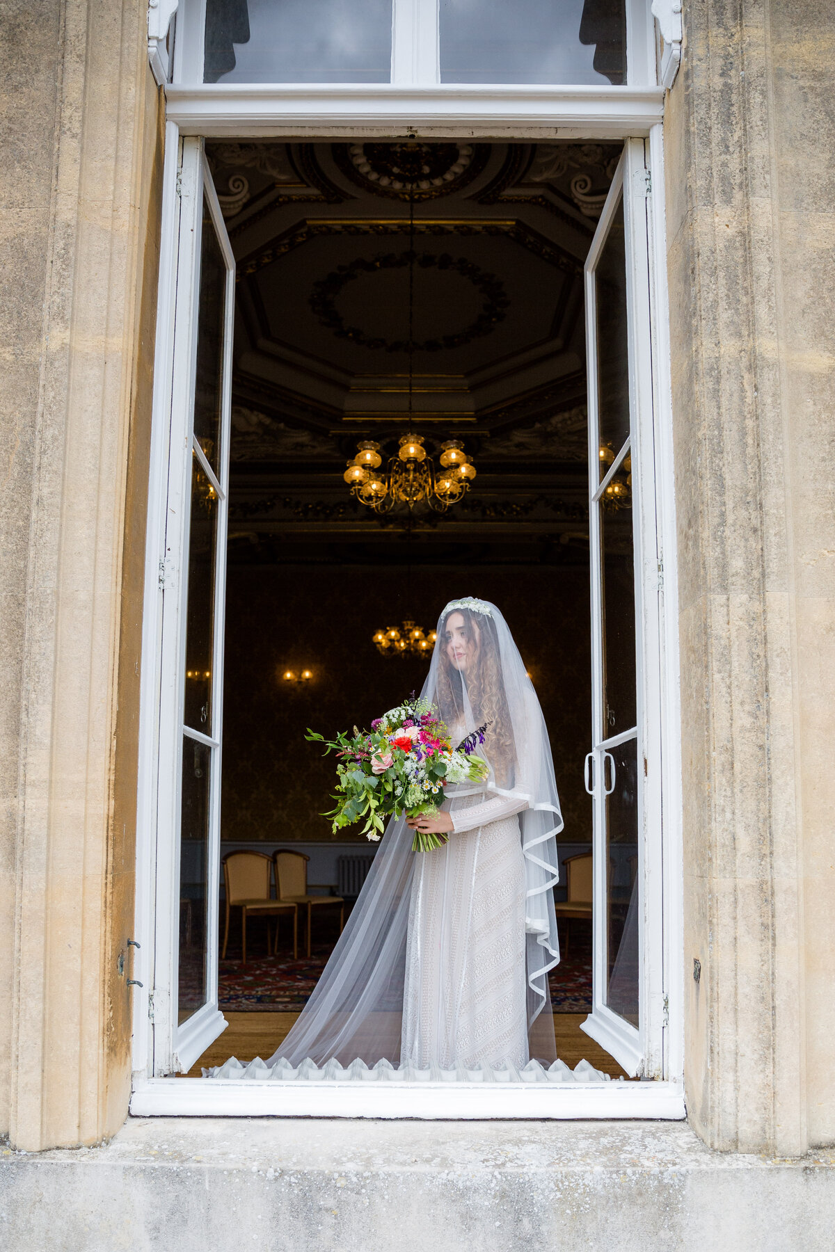 Jewish Bride holding bouquet stnading by an open wedding