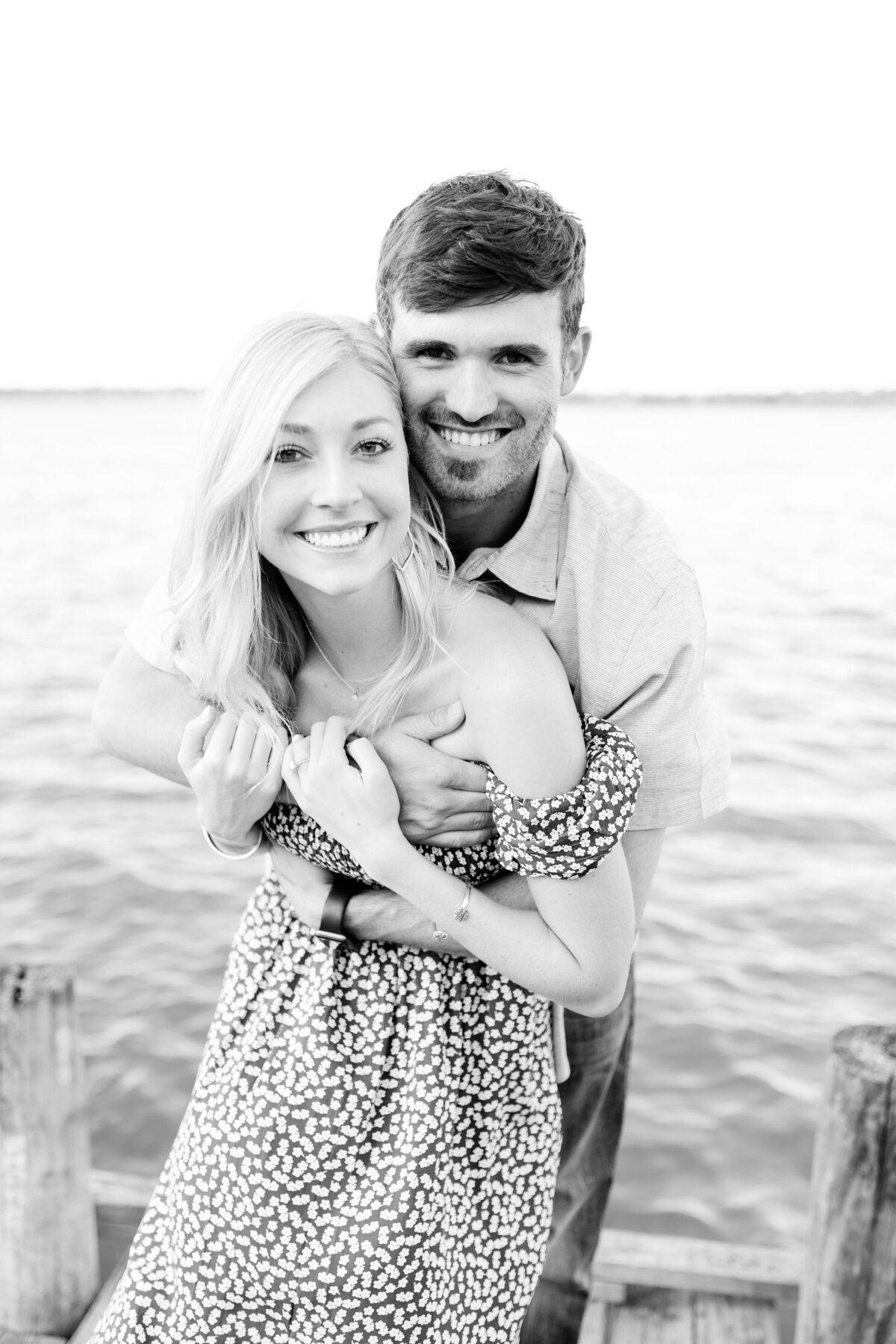 Happy couple embraces on the dock at white rock lake. Engagement pictures