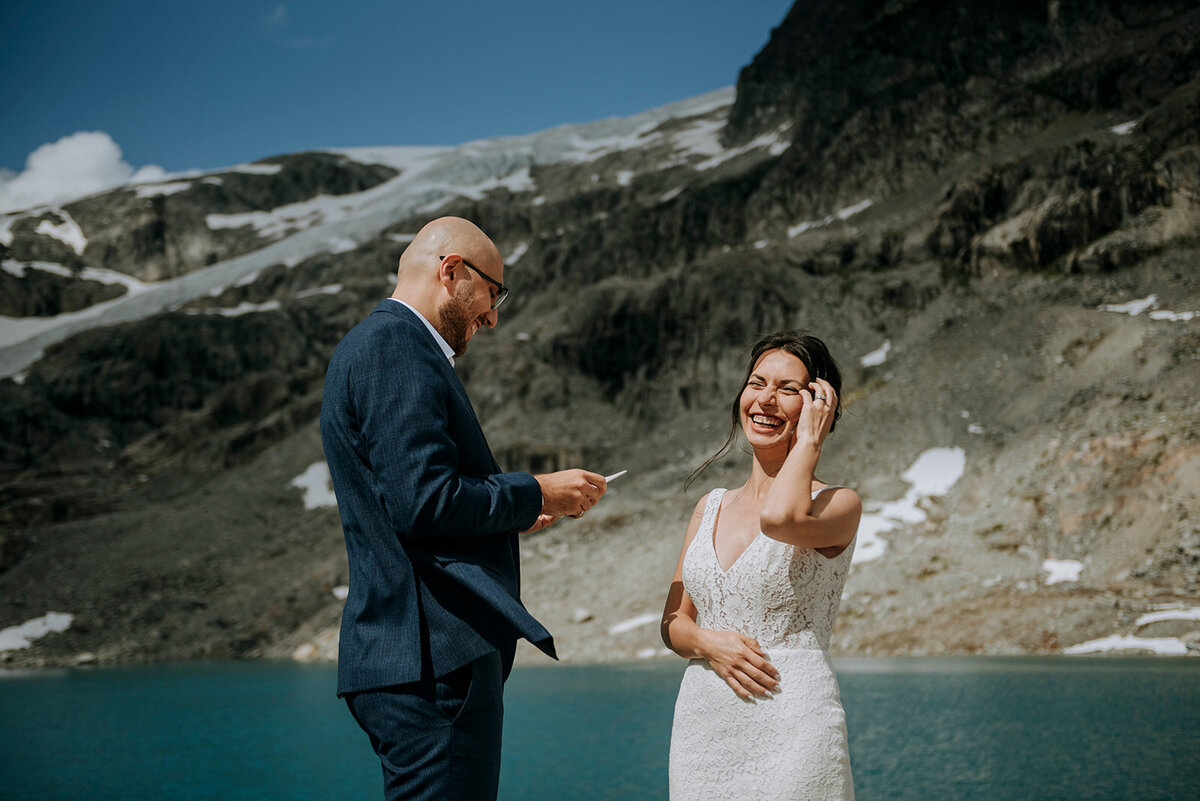 Couple shares laugh during their glacier lake elopement ceremony