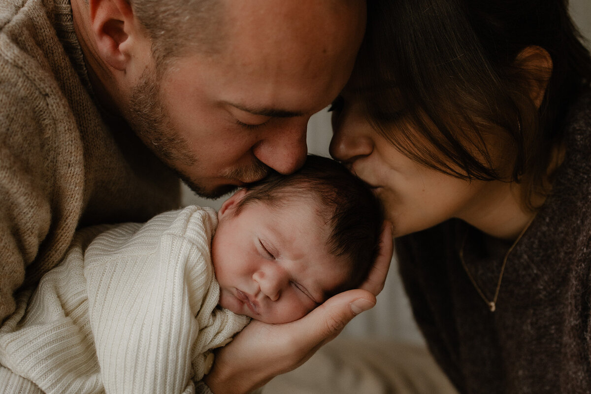 newborn baby wordt geknuffeld tijdens een newborn fotoshoot in Putte