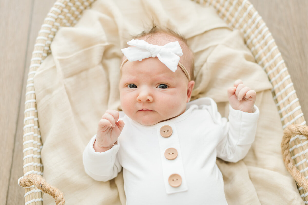 Baby wearing bow headband in wicker basket - Northern Virginia Newborn Photographer