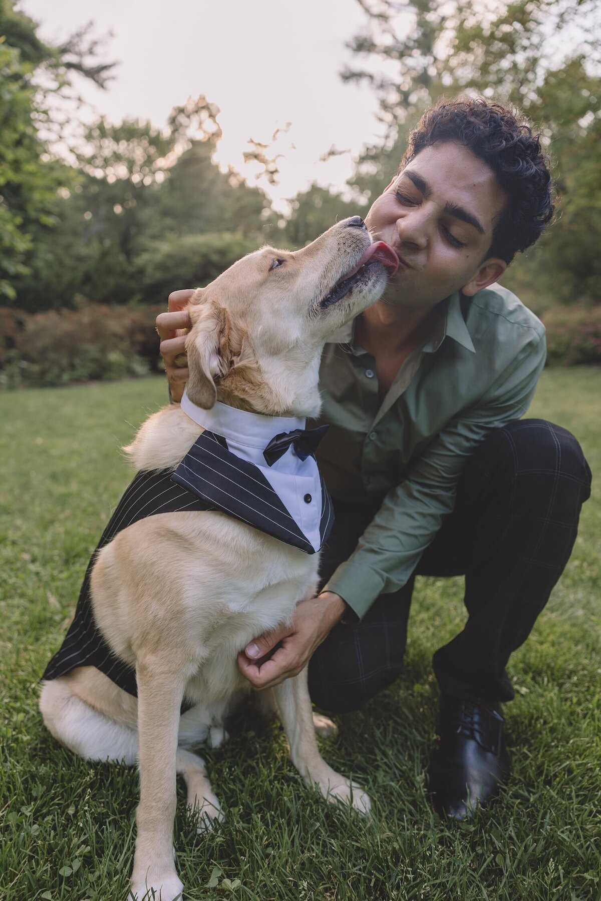 Groom-to-be hugging their dog and laughing during engagement session.