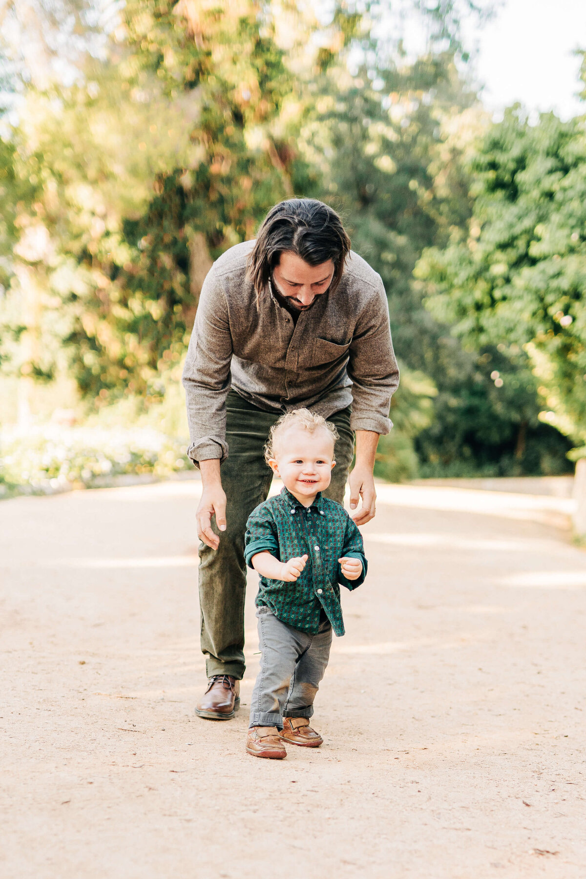 Dad plays and chases baby to keep him happy for family photos in Los Angeles