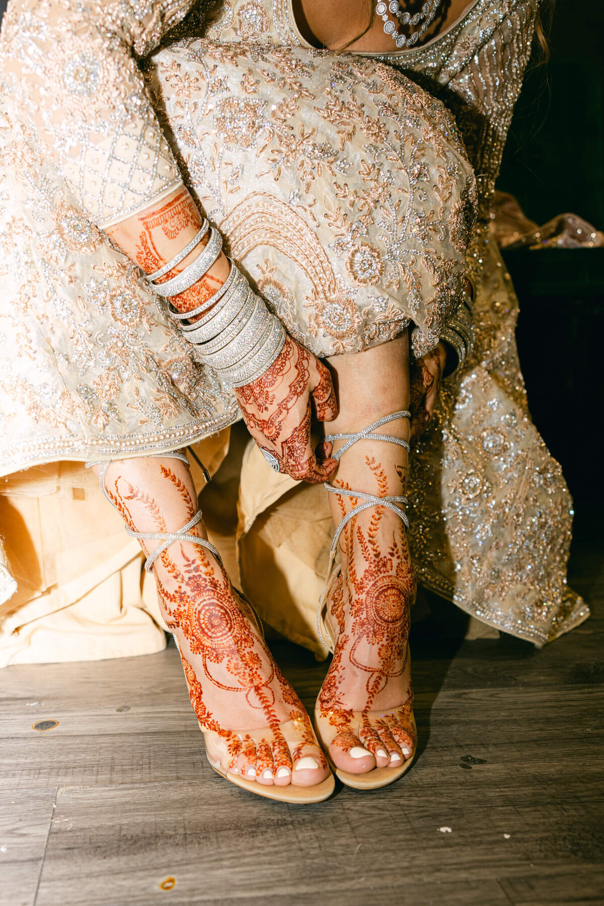 A wedding photo of the bride in her dress sitting down putting on her shoes in Dublin Ireland