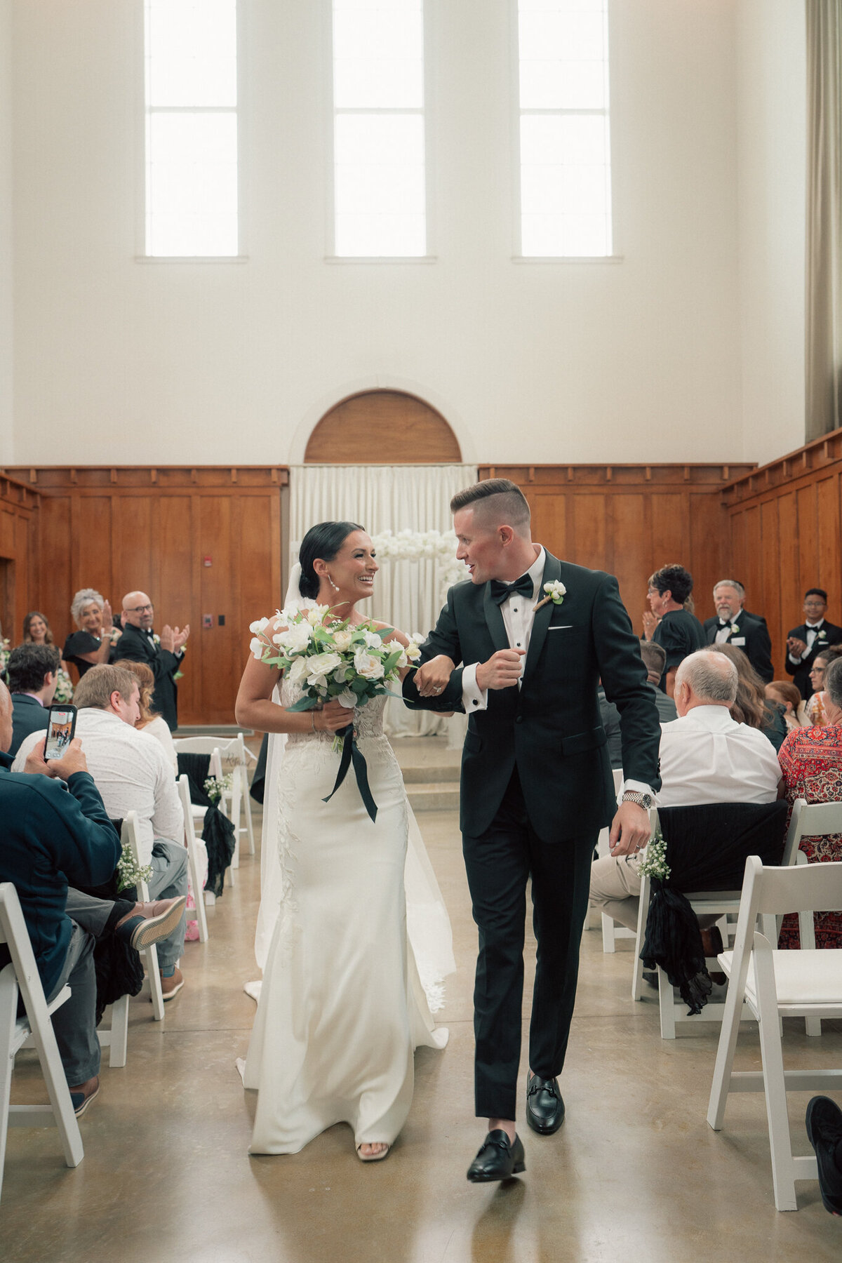 Bride and groom walking back down the aisle smiling after wedding ceremony