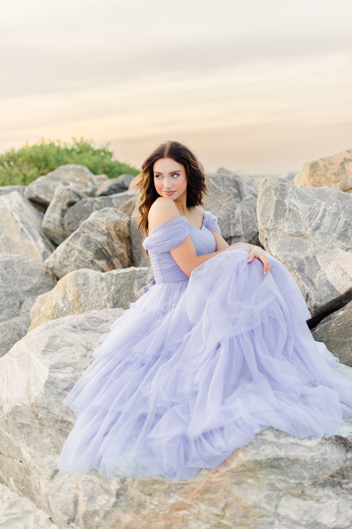 Stunning Orlando senior sitting on rocks in a luxury ball gown  taken by M. Lauren Photography