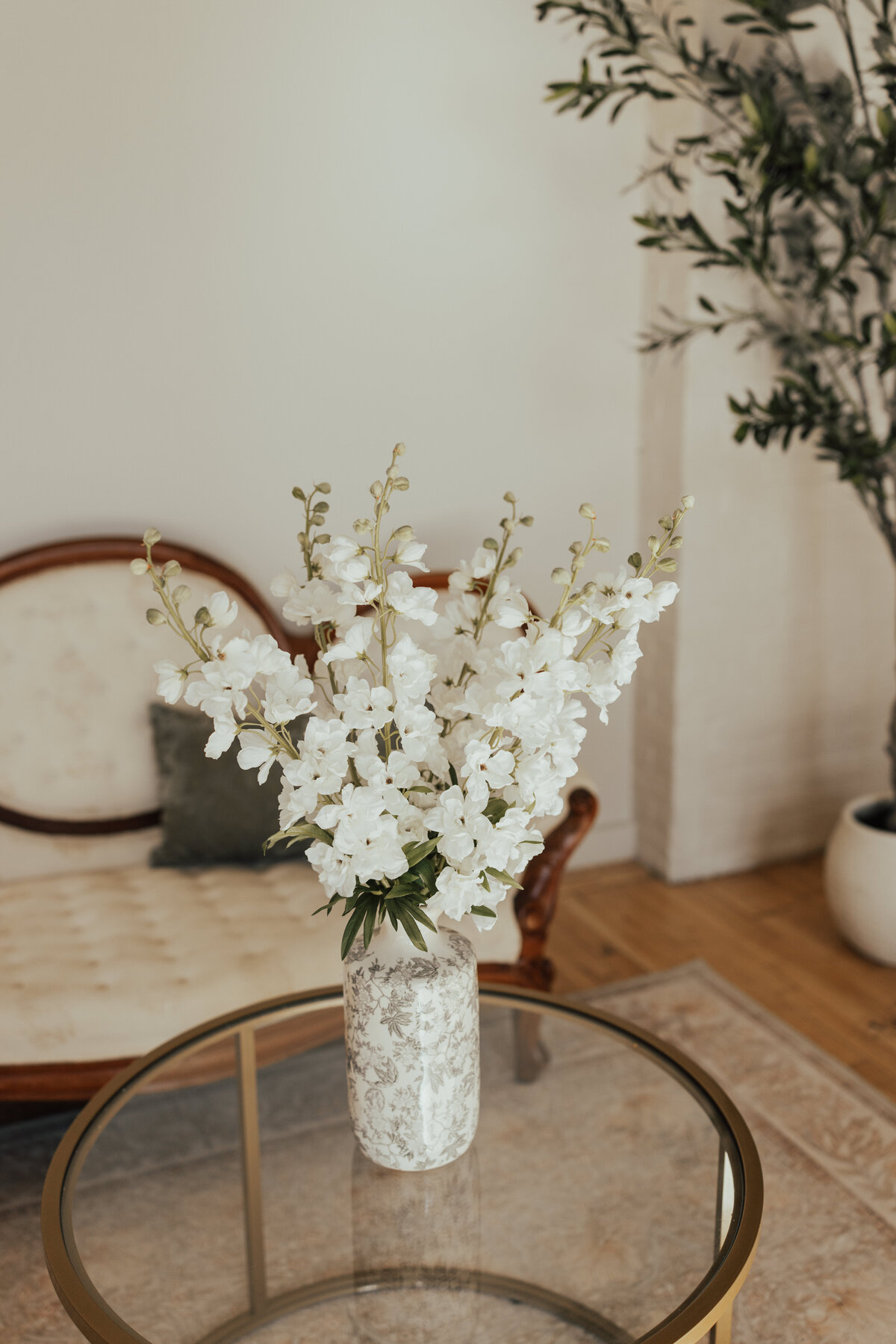 Floral display in front of a vintage couch at The Archer Atelier
