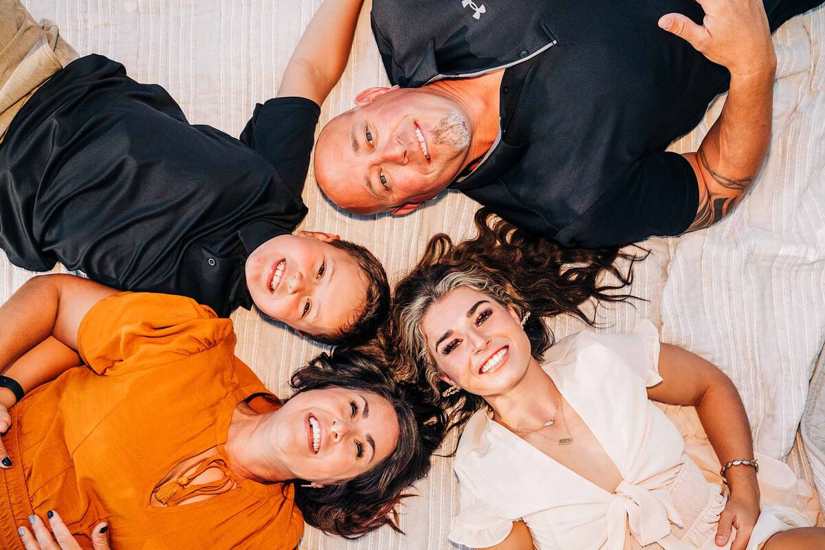 Missoula family photo laying on ground with heads together