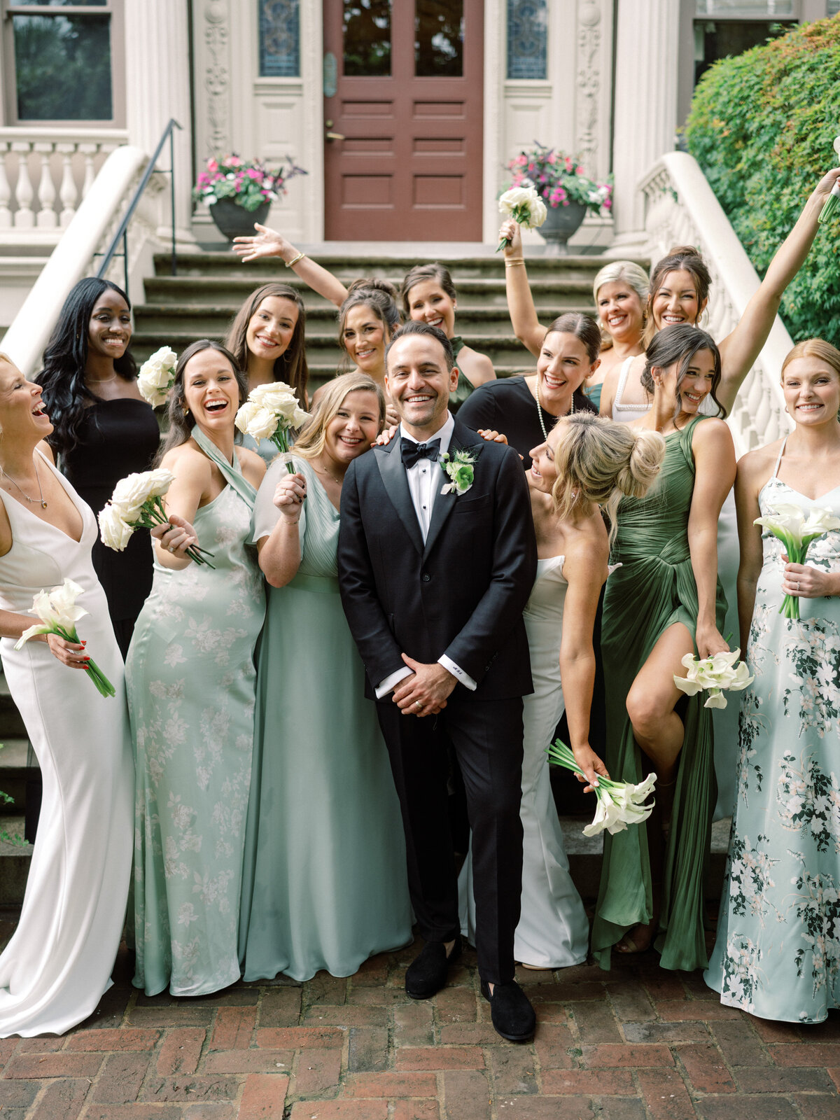 In this heartwarming image, wedding guests are captured happily celebrating in a lush garden setting, creating a beautiful scene of joy and connection among friends.