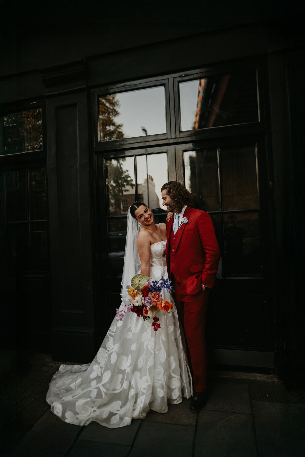 A bride and groom pose outside the front door of 100 Barrington. 