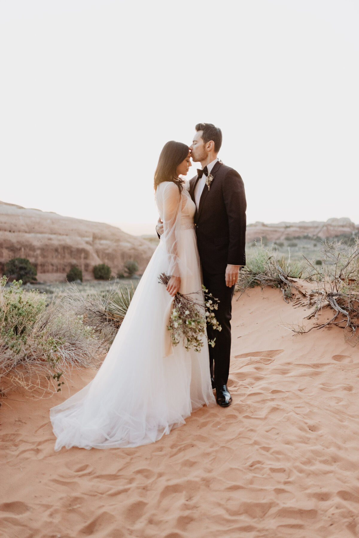 Utah elopement photographer captures groom kissing bride's forehead