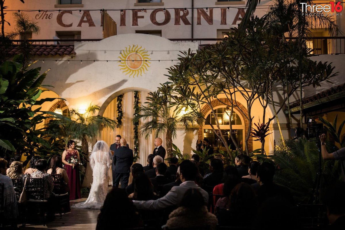 Bride and Groom stand at the altar during their night wedding ceremony at the Villa del Sol in Fullerton