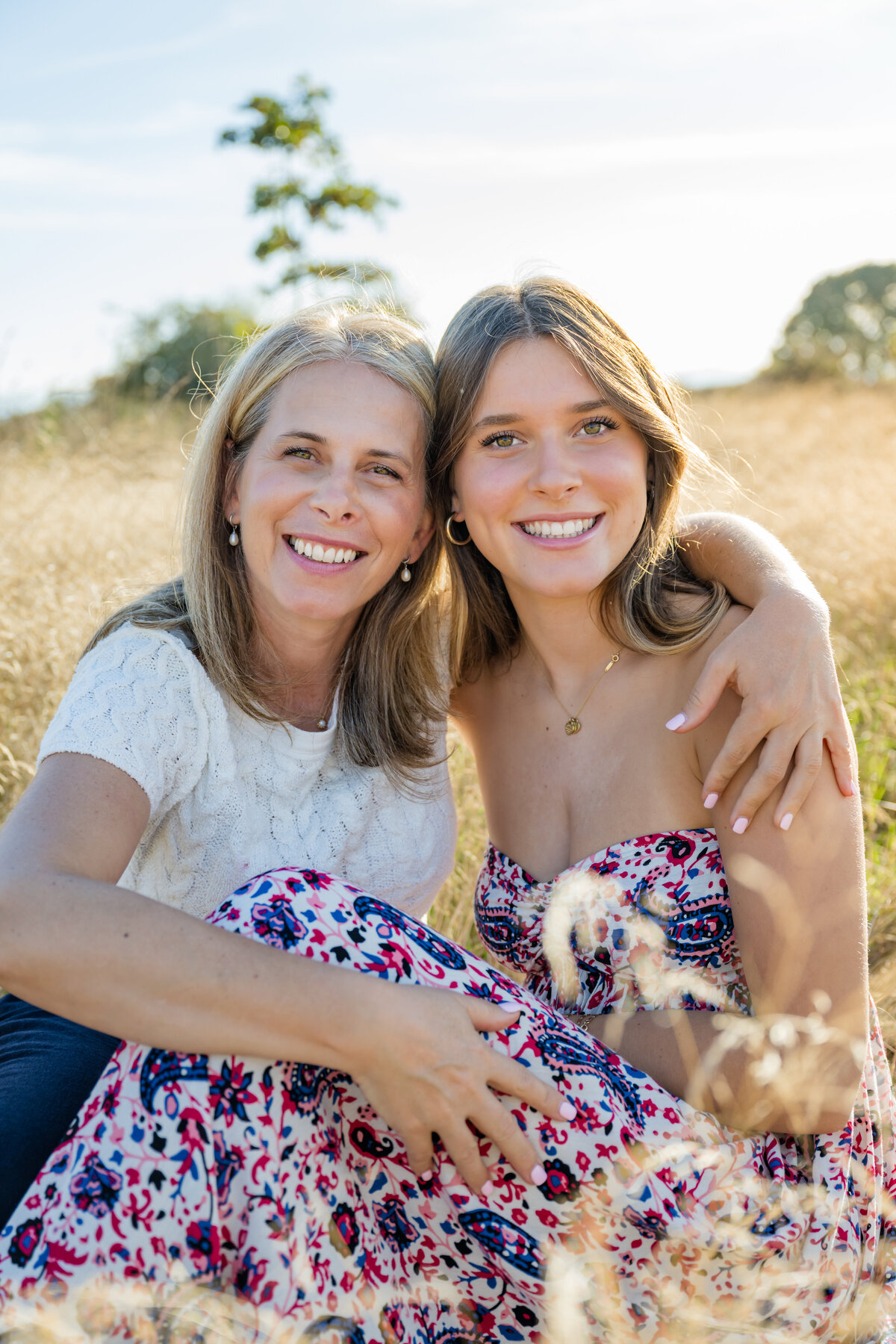 mom with daughter seated open field