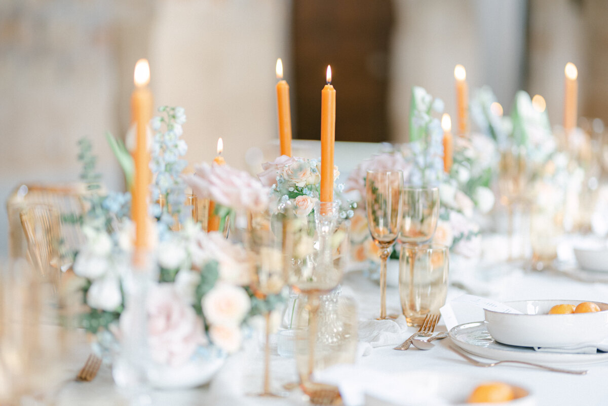 Table details for a wedding breakfast, with orange candles and details of the table set up