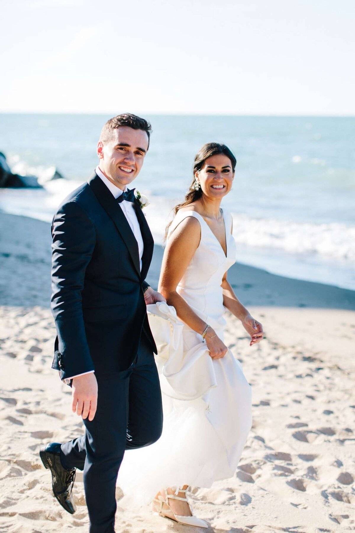 Classic and Elegant Bride and Groom take Portraits along the Beach at a Luxury Michigan Lakefront Golf Club Wedding.