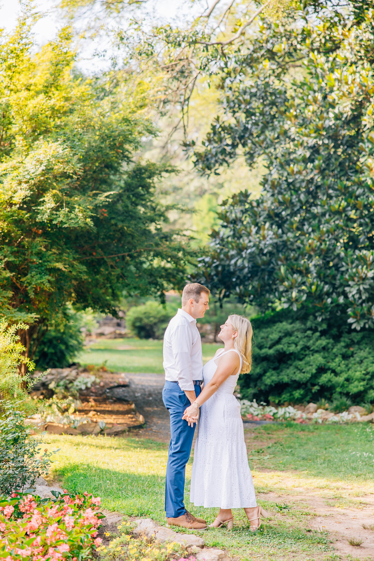 couple holding hands and staring at each other in beautiful lush gardens in greenville south carolina