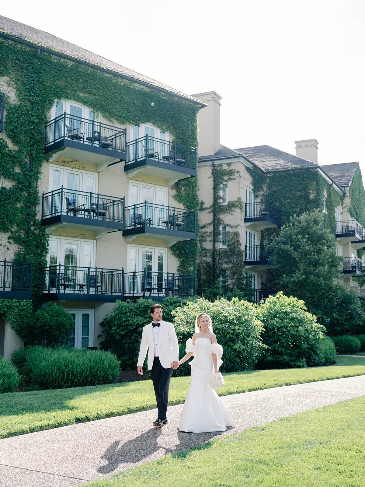 couple walks with ivy walls as a backdrop at salamander resort