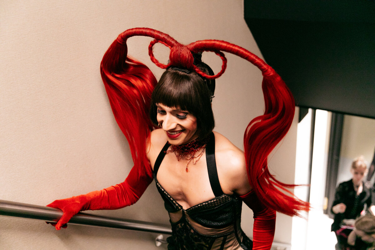 Moulin Rouge performer in kostuum op de trap backstage.