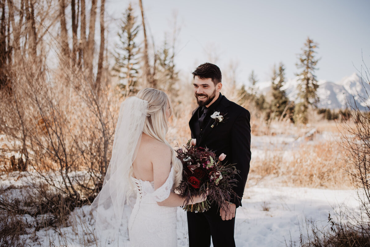 Jackson Hole Photographers capture groom smiling during first look before winter elopement
