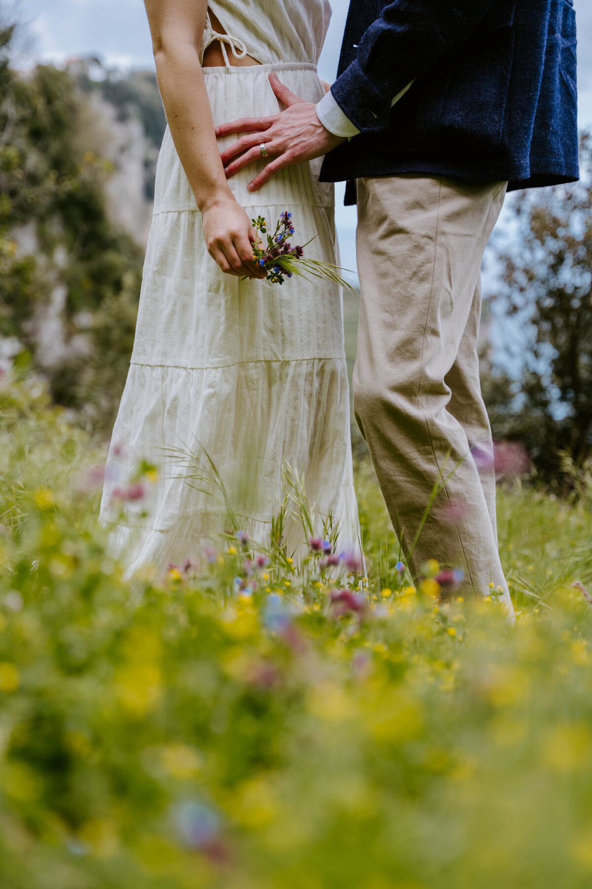 Couple holding hands in wildflowers