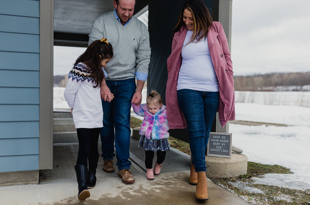 Maternity photographer capturing a mom, dad, and two children walking outside.